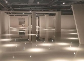 Polished concrete floor in automotive showroom treated with lithium silicate densifier showing high gloss mirror-like finish and clear light reflection
