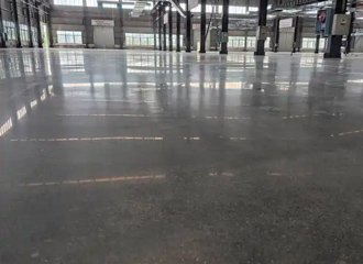 Silicate densified concrete floor in industrial facility with heavy machinery showing durable dust-free polished surface
