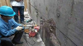 Sodium silicate waterproofing being applied to concrete wall with roller forming penetrating sealer that blocks water ingress
